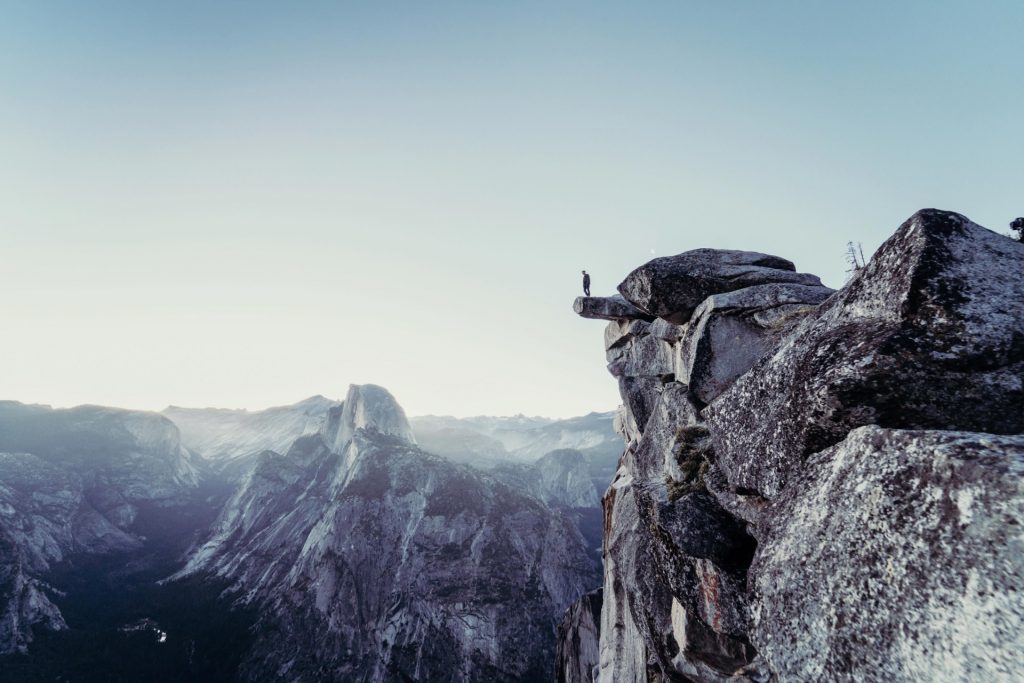 man standing at edge of cliff